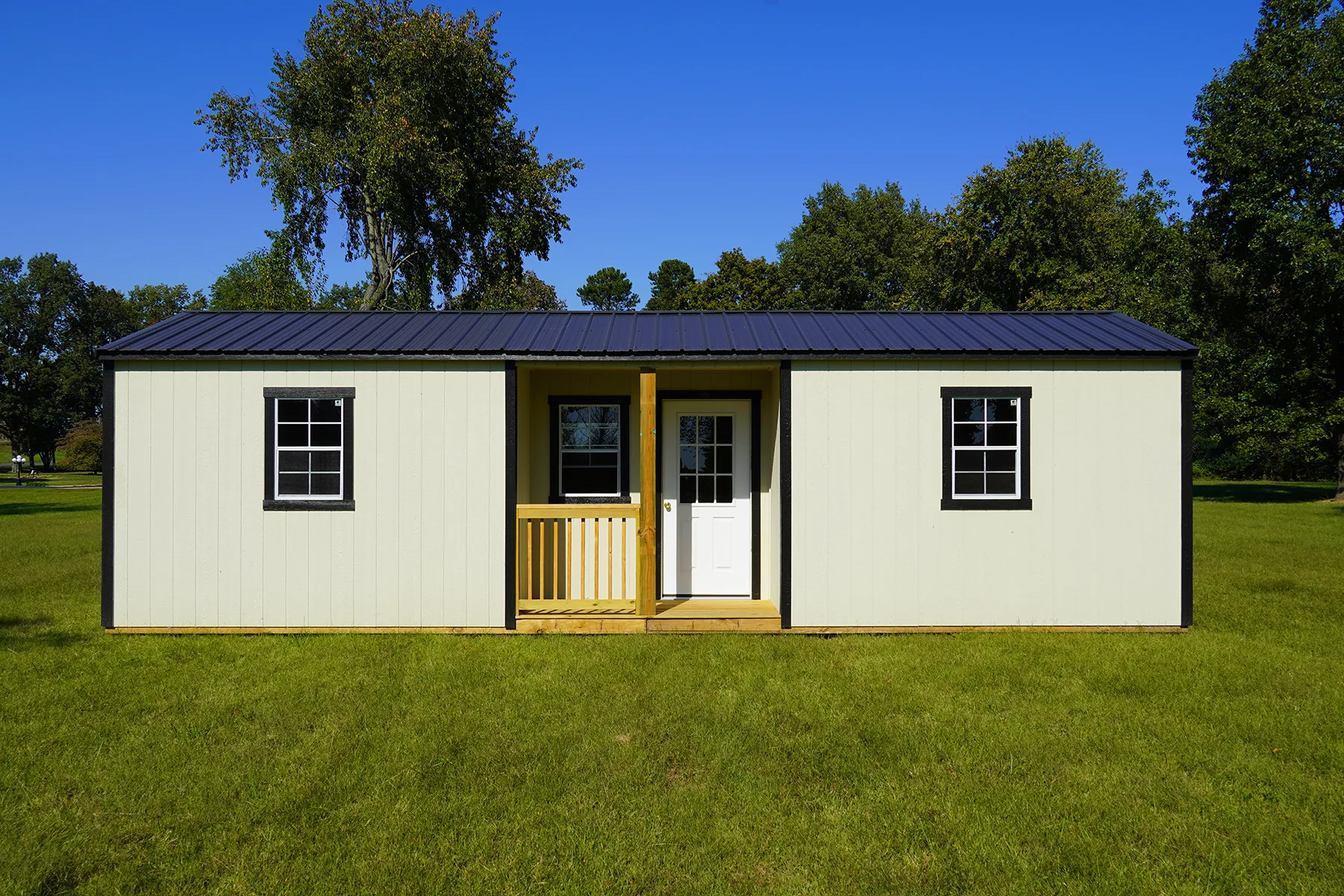 Cream Premier center cabin shell with a centered porch and black metal roof